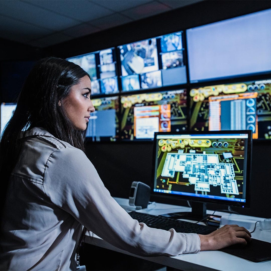 woman using computer in front of multiple screens