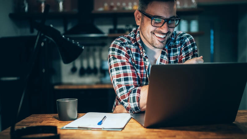 Young man using laptop and laughing