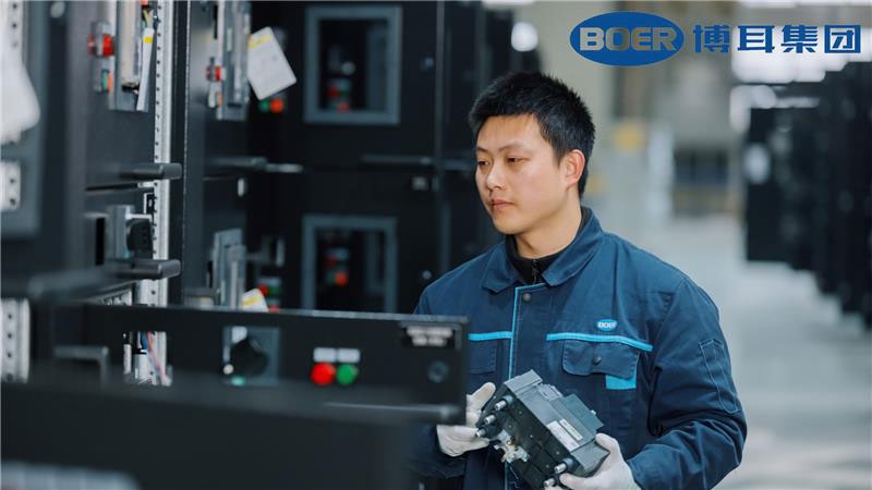 A person in a factory holding a machine