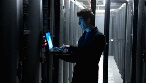 IT technician programming computer equipment in a server room