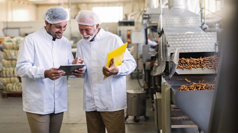 A few men in white coats in a factory