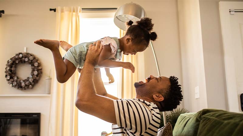 A person holding a baby up in the air