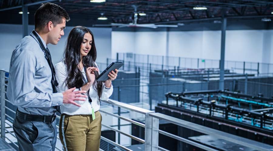 Ejecutivos de negocios usando su tableta digital en el cuarto de servidores