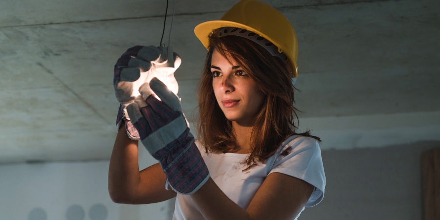 Women Electrician doing a connection and lighting a bulb