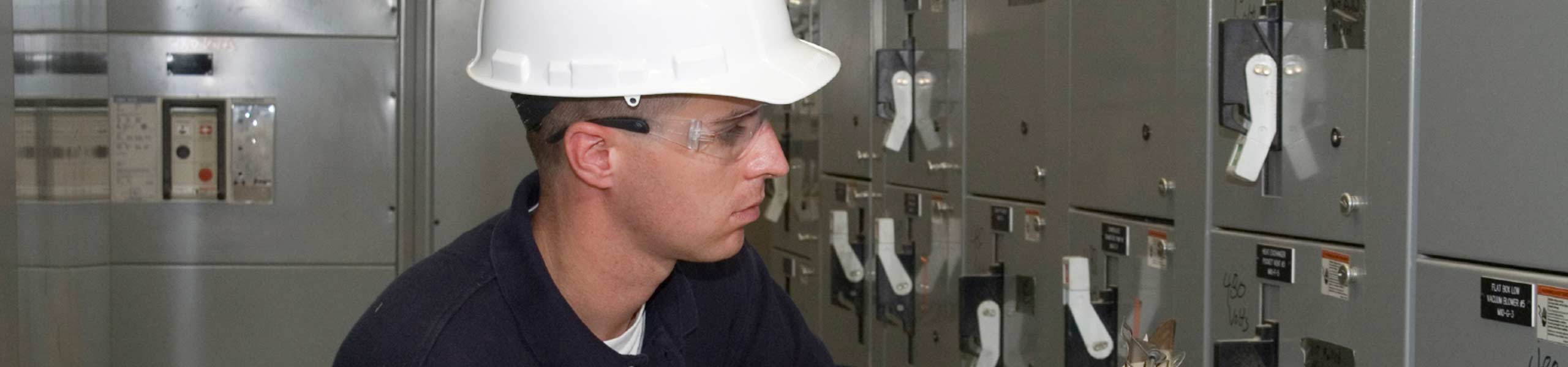 An employee checking on the electrical machine and writing down what he notices, energy management, power management, field service