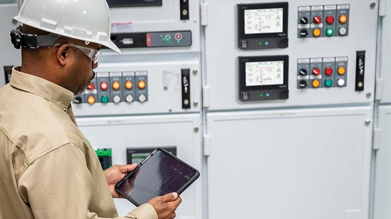 A person in a hard hat using a tablet