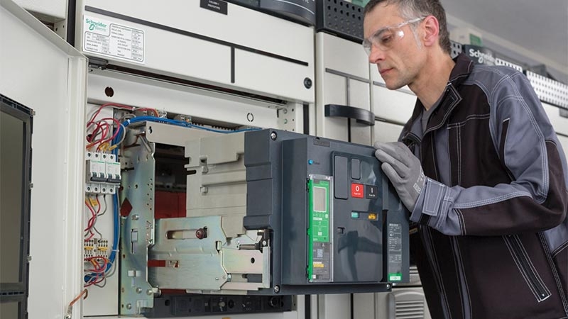 A person wearing goggles and working on a machine