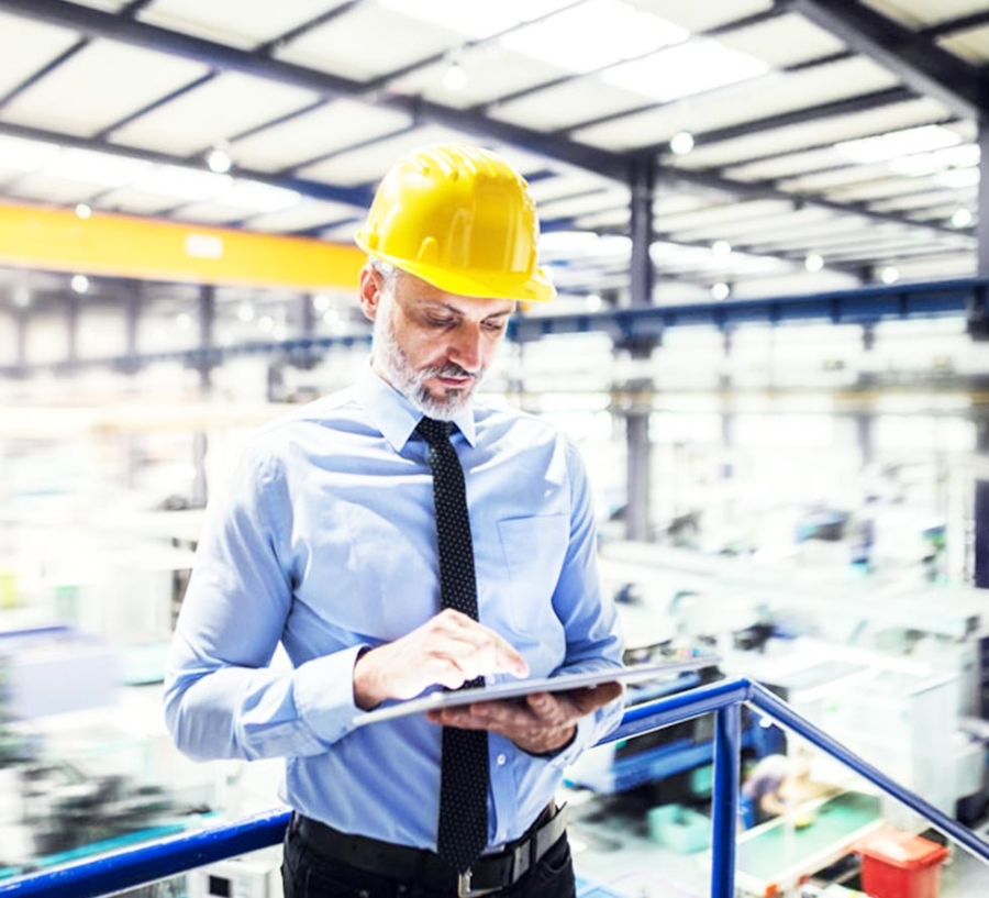 An industrial man engineer working with tablet in a factory.