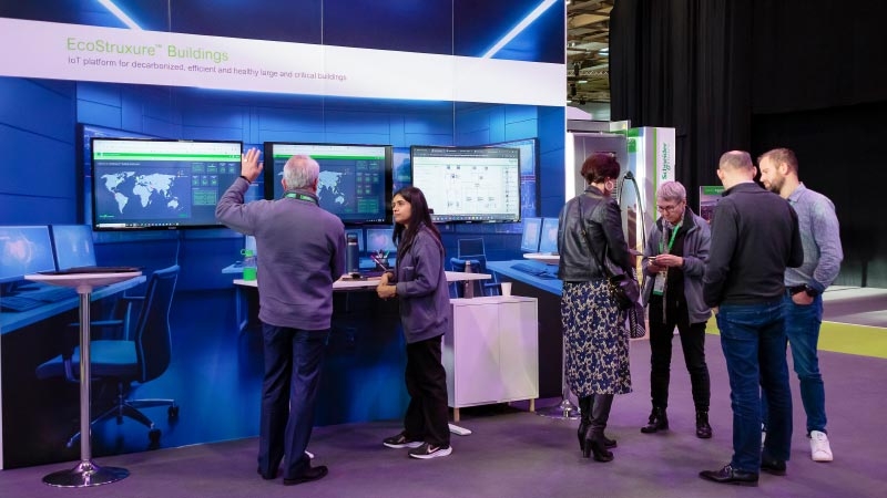 A group of people standing in front of a computer screen Buildings