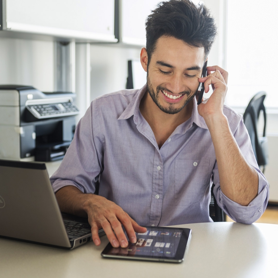 A male employee working on his laptop in office