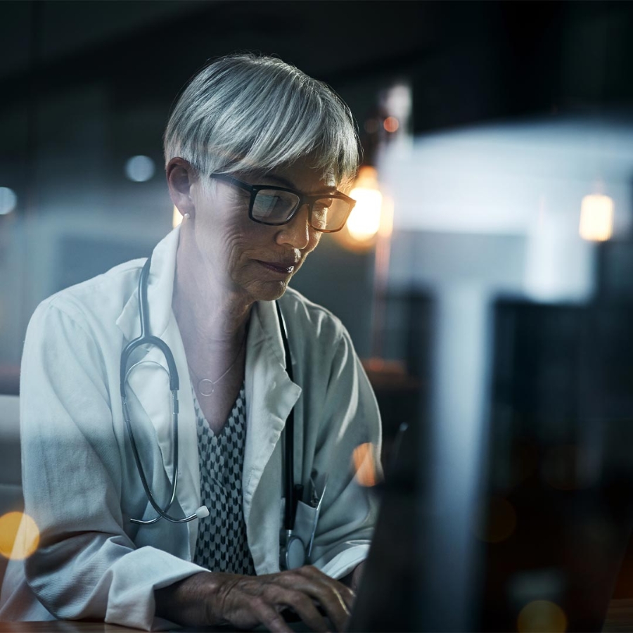 A person in a white coat and glasses