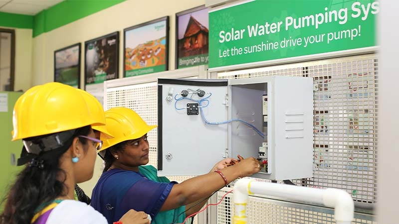 A group of people wearing hardhats working on solar water pump