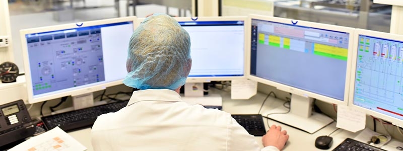 A worker monitors production in the control center using automotive digital solutions