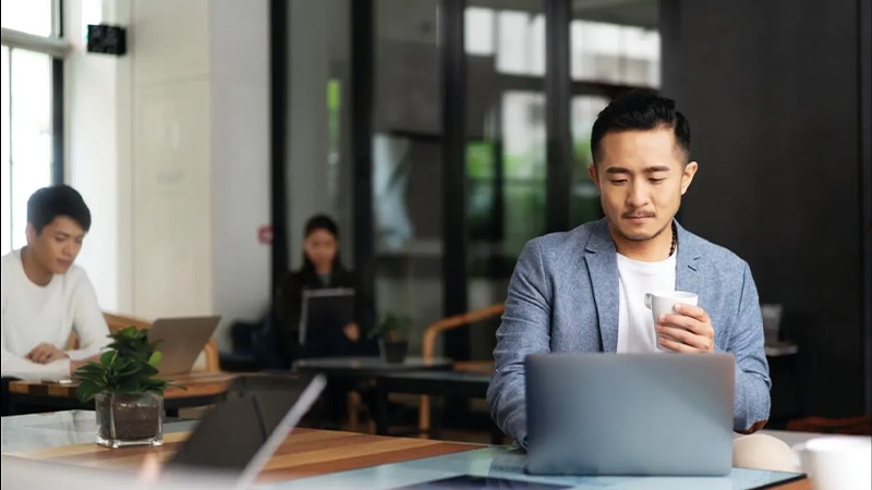 A person sitting at a table with a computer