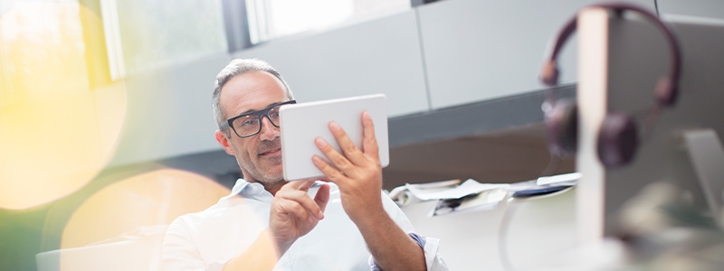 Businessman using digital tablet at office desk