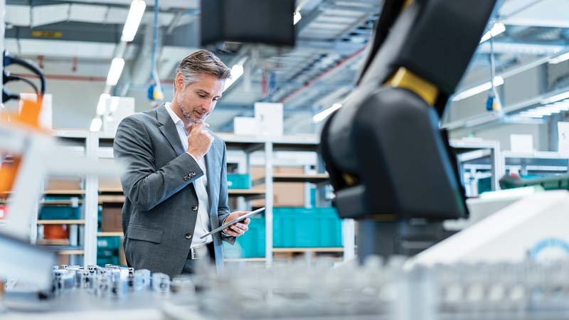 A person in a suit looking at a tablet