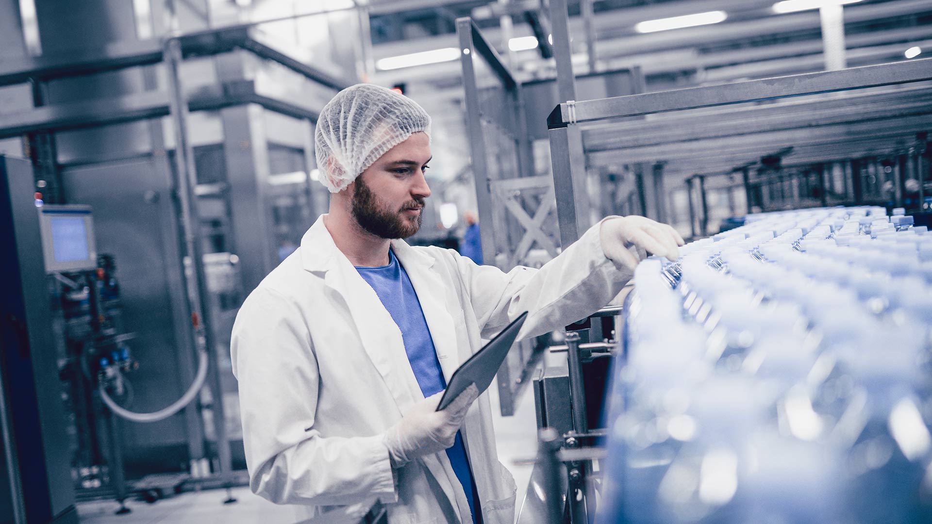 worker working in a factory while holding a digital tablet