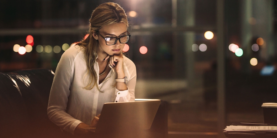 a young business professional working in a corporate office at night