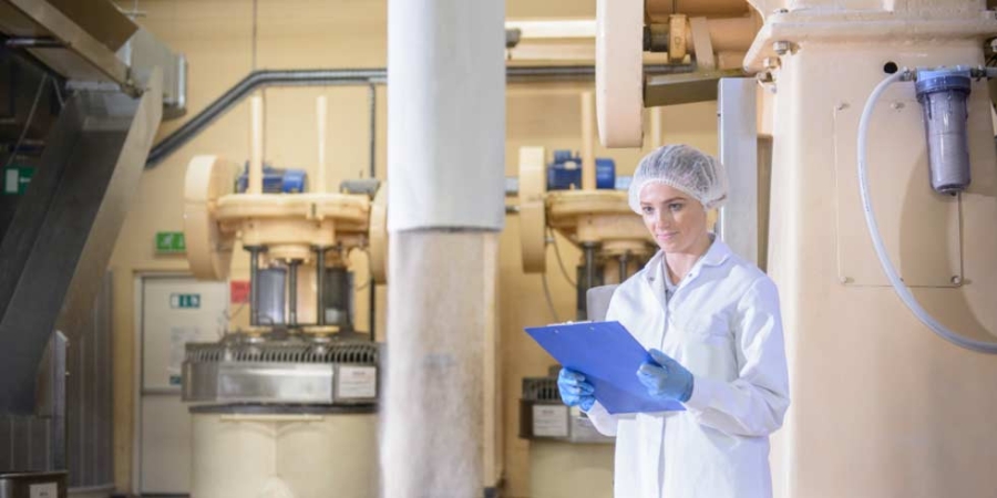 Arbeiter in Keksfabrik überprüft Zutaten in Form von Massengütern, Nachhaltigkeitsberichte, Nahrung und Genuss.