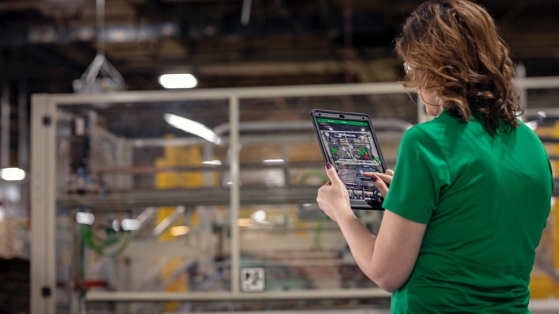 a woman in a green shirt holding a tablet