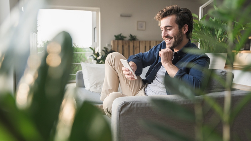 Man is smiling while looking in to his mobile