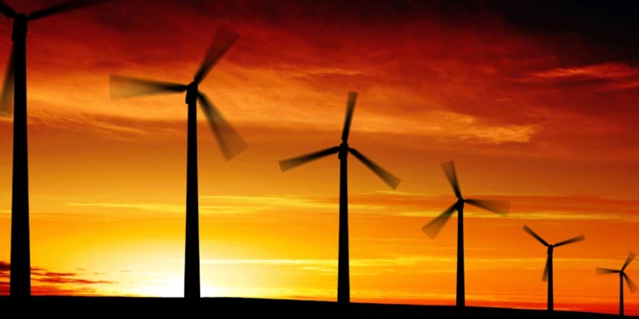 Větrné turbíny v otevřené oblasti se západem slunce na pozadí, energie a udržitelnost.