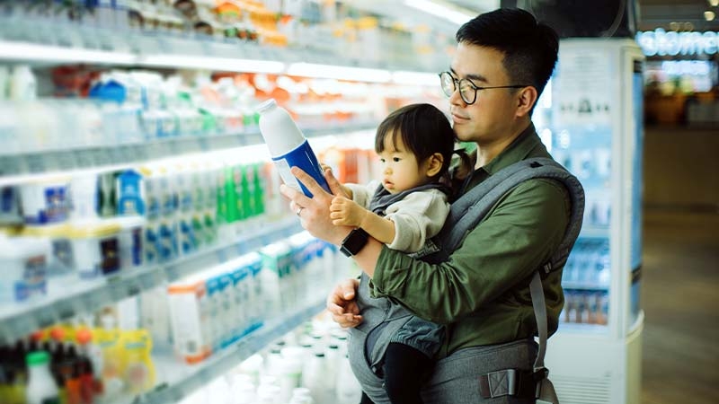 A person holding a baby in a grocery store