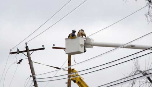 Pracovníci elektroinstalací obnovují napájení a distribuci elektřiny.