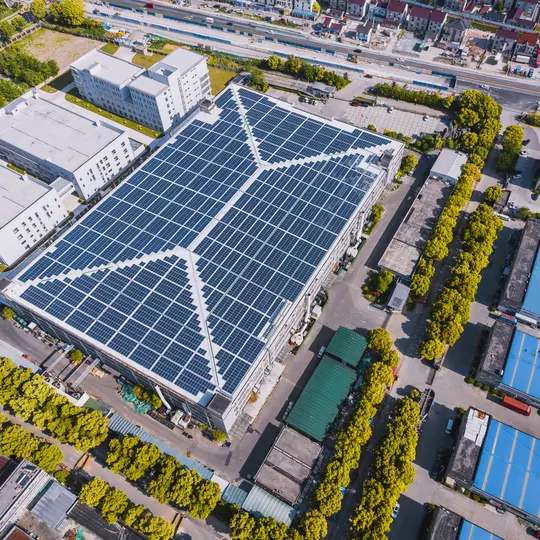 An aerial view of a solar panel factory, producing clean energy for electric utilities and smart grid system