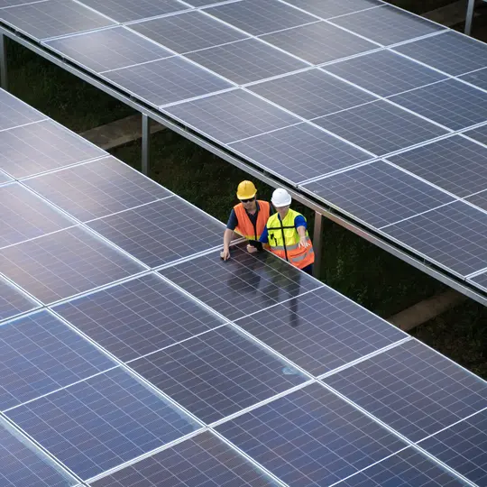 Aerial view solar energy team working at solar power station.