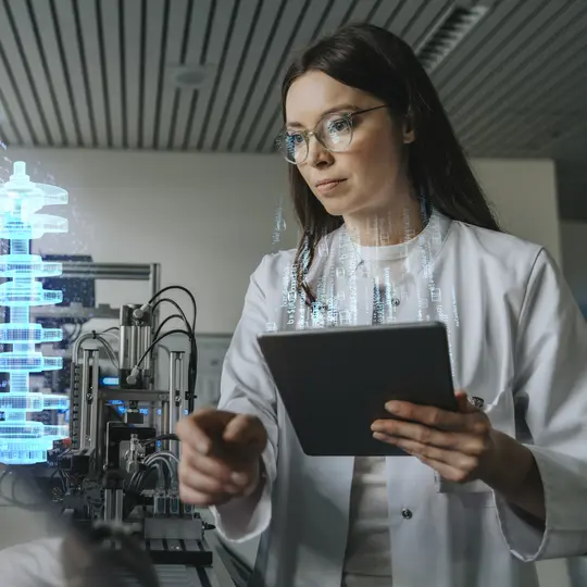 Female engineer with digital tablet examining development of industrial product