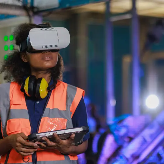 Female working with virtual reality (VR) Glass and digital tablet to control the automation robot arm machine the assembly line.