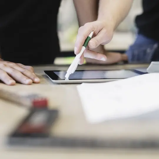 Midsection of trainee and teacher using digital tablet