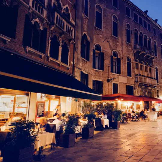 Italy, Veneto, Venice, busy restaurants and bars lining narrow street