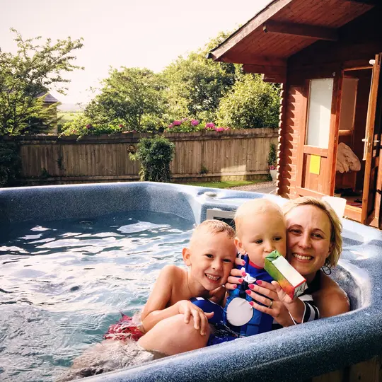 Une mère s'amuse avec ses enfants dans une piscine grâce aux solutions électriques apportées par le programme partenaire électricien