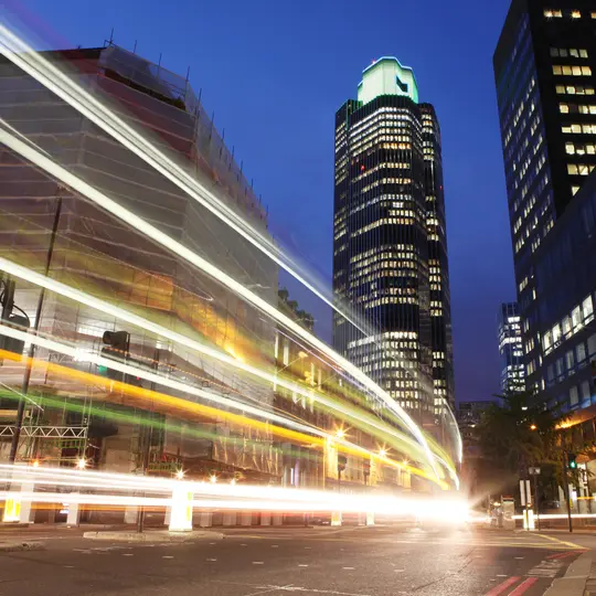 City of London at night with passing car light trails and Tower 42 in the background