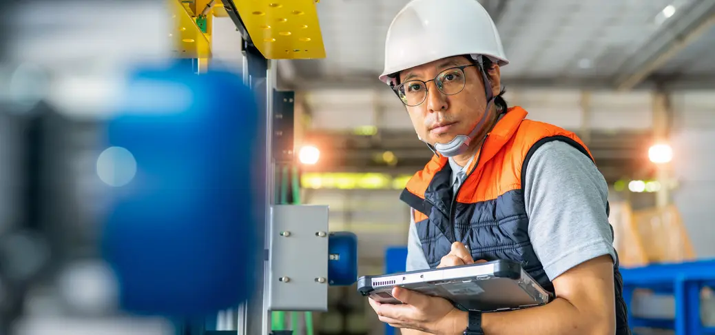 Japanese males engineer input sequence of program to strapping machine with digital tablet and digitalization display in automated production line.