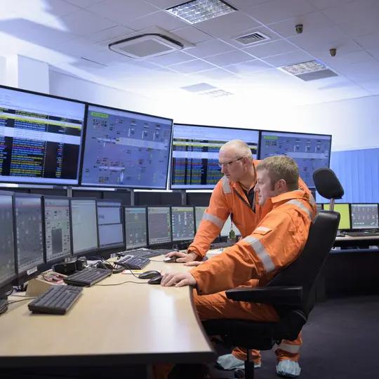 Experts in a control room monitoring power safety at sea