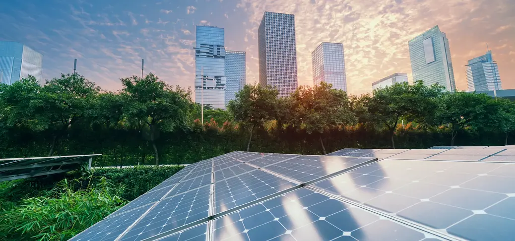 Ecological energy renewable solar panel plant with urban landscape landmarks in sunset