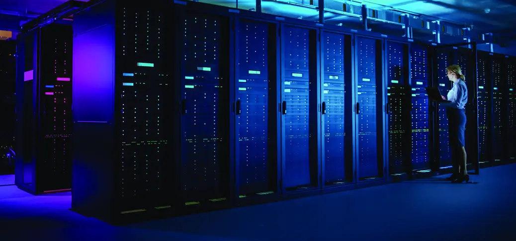 A large data center room with a specialist in the back controlling devices