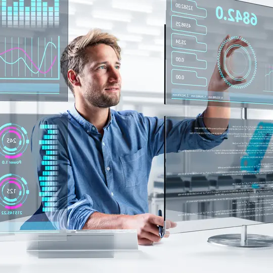 An engineer works in front of different touch screens in a factory