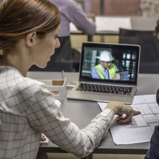 Two architects having video conference with an engineer colleague