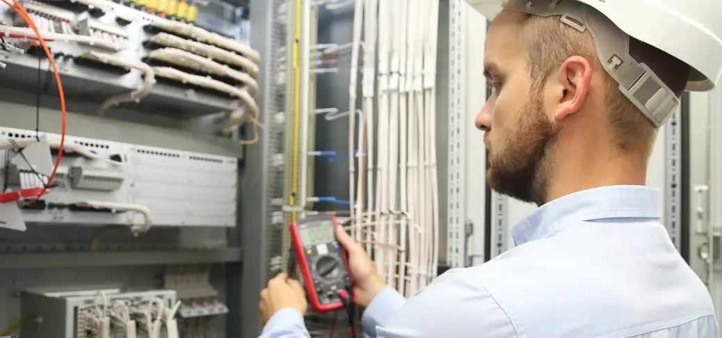 Male engineer checking electrical system with electronic tools