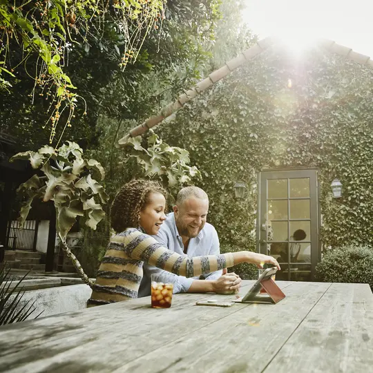 Smiling father and daughter looking at the tablet