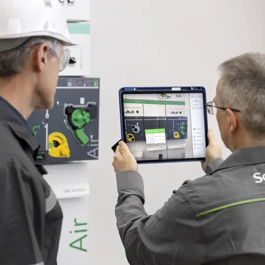 Panel builders look at the tablet and conduct maintenance services