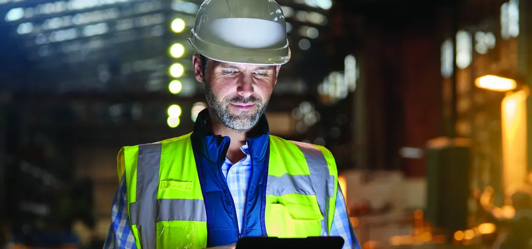 Male engineer working at glowing digital tablet