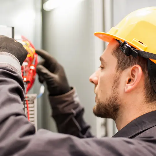 Closeup of electrician engineer works with electric cable wires