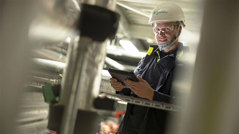 A person in a hard hat using a tablet