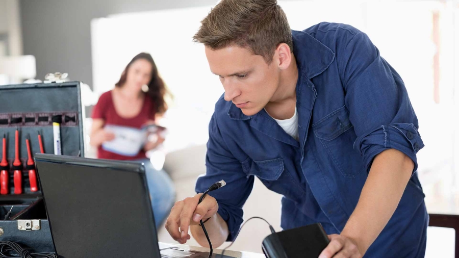 a young IT technician repairing computer