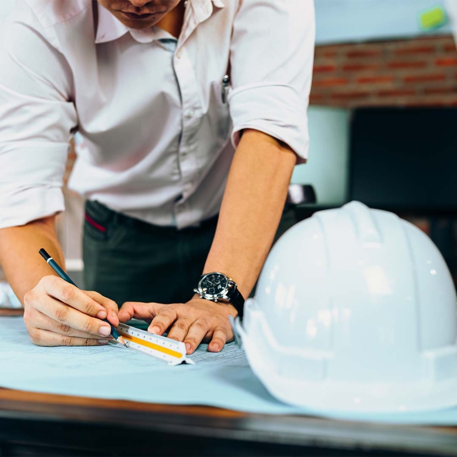 A person writing on a blueprint